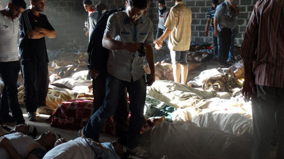 Syrian opposition's Shaam News Network shows people inspecting bodies of children and adults laying on the ground as Syrian rebels claim they were killed in a toxic gas attack by pro-government forces in eastern Ghouta, on the outskirts of Damascus on August 21, 2013.(AFP Photo / Shaam News Network)