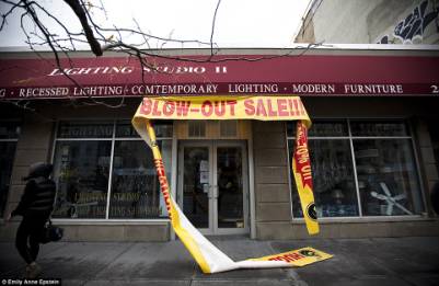 Overblown: A lighting shop in New York is closed after the storm. Strong winds brought down part of a banner which had advertised the business's 'blow-out sale'