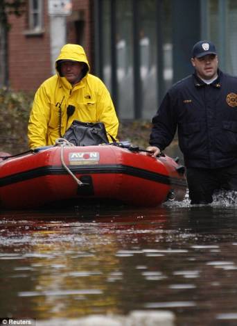 Rescue workers patrol a flooded street in Hoboken, New Jersey