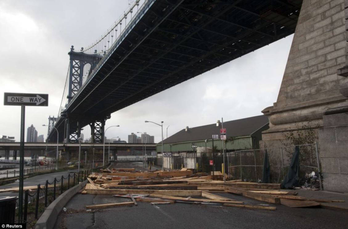 Road blocked: Pieces of lumber displaced from a yard by rising flood waters are seen beneath Manhattan Bridge in the aftermath of Hurricane Sandy