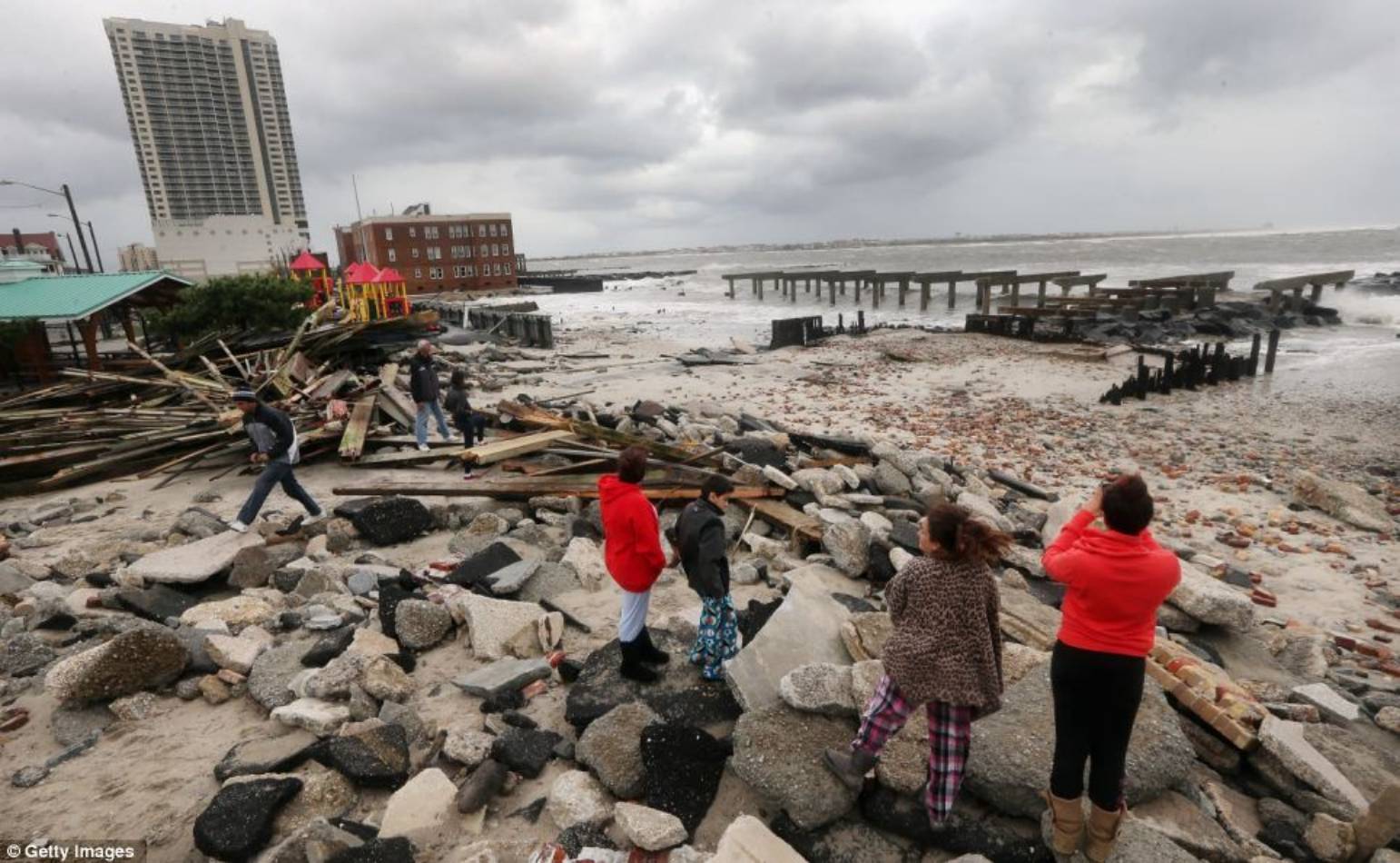 Rubble: People in Atlantic City view the area where a 2000-foot section of the 'uptown' boardwalk was destroyed by flooding