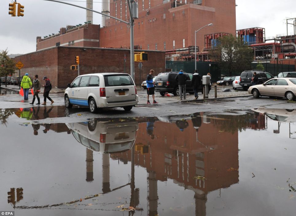 Pedestrians skirt around flooded areas on the Lower East Side of Manhattan as they try to get back to normal
