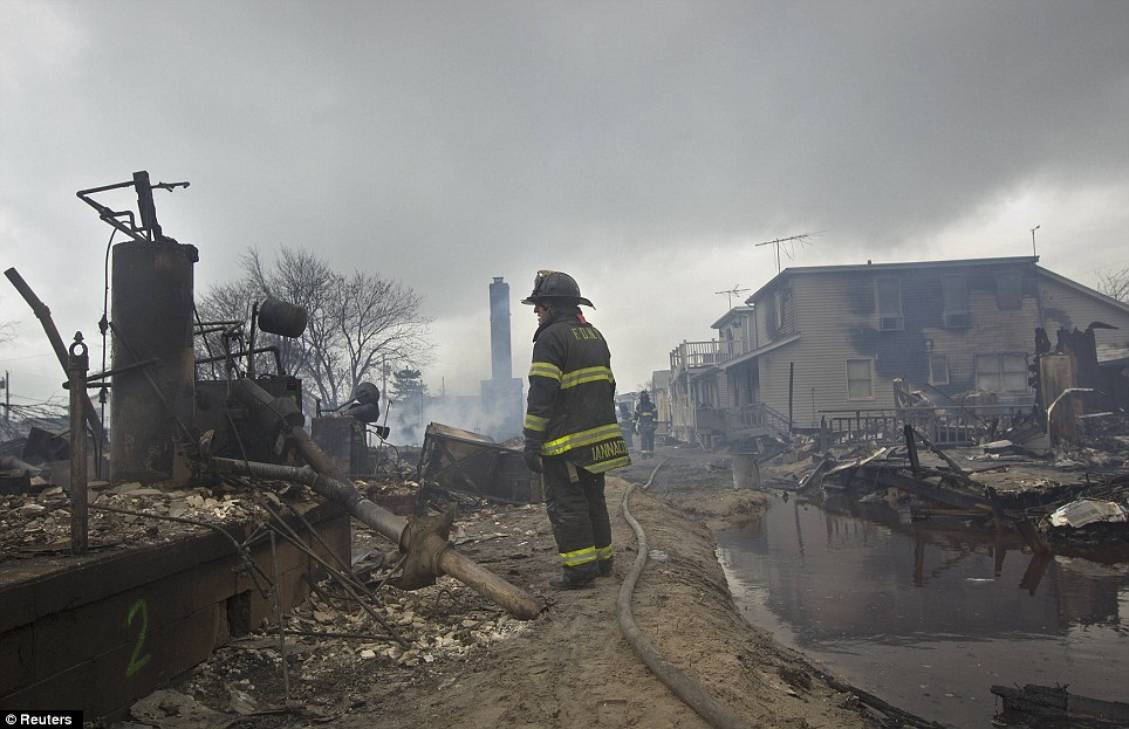 Challenge: Firefighters tackle a blaze in the Breezy Point section of the Queens borough of New York, in which more than 80 homes were destroyed
