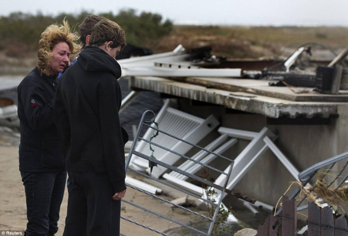 Tearful: A woman cries as she and others look at homes devastated by Superstorm Sandy at the Breezy Point section of the Queens borough of New York