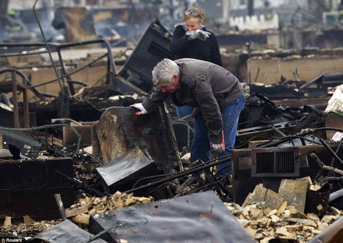 Upsetting: Tom and Deidre Duffy look through the wreckage of their home at Breezy Point, in Queens, which was devastated by fire