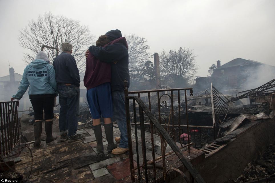 Destroyed: Residents look over the remains of burned homes in the Rockaways section of New York