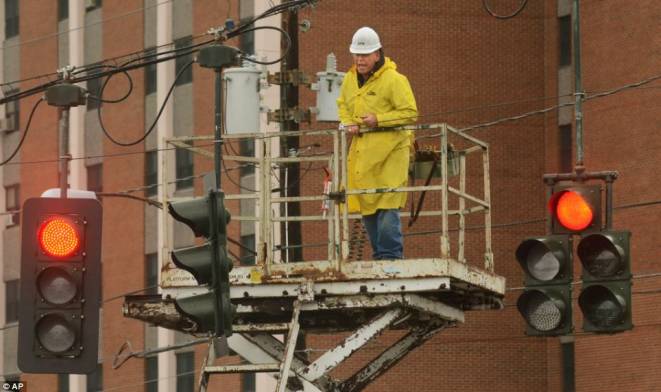 Time to heal: City of Elmira N.Y., electrician, Nate Battle fixes a traffic light that was downed from high winds 