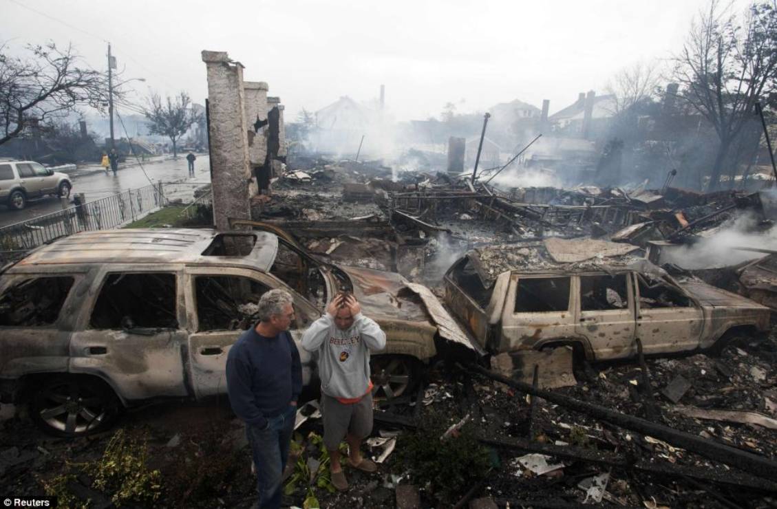 Shock: Residents look over the remains of burned homes in the Rockaways section 
