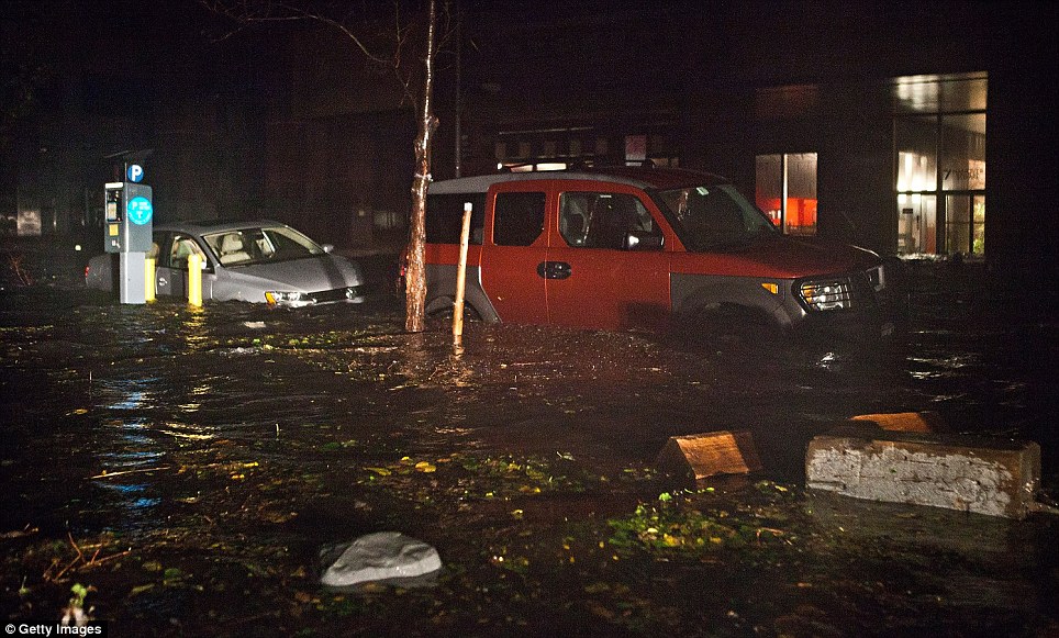 Cars were flooded in the Financial District of New York as Hurricane Sandy threatens 50million people on the East Coast